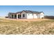 Exterior of home with a covered patio, black trim windows, and a large grassy yard at 11564 E Windsor Way, Florence, AZ 85132