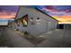 Exterior view of a home with a two-car garage illuminated at twilight at 11564 E Windsor Way, Florence, AZ 85132