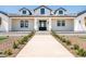 Beautiful white farmhouse with black accents, dormer windows, and a lush green lawn at 11564 E Windsor Way, Florence, AZ 85132