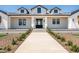 Stunning new construction home featuring a black front door, covered porch, and meticulous landscaping at 11564 E Windsor Way, Florence, AZ 85132