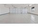 Well-lit two-car garage showcasing epoxy flooring and modern garage doors at 11564 E Windsor Way, Florence, AZ 85132