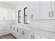 Bright kitchen features white cabinets, black hardware, and elegant marble countertops at 11564 E Windsor Way, Florence, AZ 85132