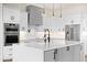 Modern kitchen with island, pendant lights, white cabinets, and stainless steel appliances at 11564 E Windsor Way, Florence, AZ 85132
