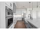 Modern kitchen with stainless steel appliances, white cabinets, and a large island at 11564 E Windsor Way, Florence, AZ 85132