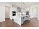 Bright kitchen features a large island, stainless appliances, white cabinets, and wood flooring at 11564 E Windsor Way, Florence, AZ 85132