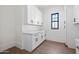 Clean laundry area showcasing white cabinets, contemporary hardware, and stylish flooring at 11564 E Windsor Way, Florence, AZ 85132