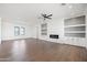 Spacious living room with a modern fireplace, built-in shelves, and a ceiling fan at 11564 E Windsor Way, Florence, AZ 85132