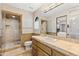 Bathroom featuring a glass shower, a toilet, tan counters, and a large mirror at 11773 E Desert Trail Rd, Scottsdale, AZ 85259