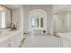 Bright bathroom featuring tub with chandelier, mosaic tile flooring, vanity, and glass enclosed shower at 11773 E Desert Trail Rd, Scottsdale, AZ 85259