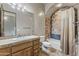 Bathroom featuring tiled floors and walls, a wooden vanity, bathtub, and large framed mirror at 11773 E Desert Trail Rd, Scottsdale, AZ 85259