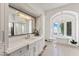 Elegant bathroom featuring tub with chandelier, mosaic tile flooring, and double vanity at 11773 E Desert Trail Rd, Scottsdale, AZ 85259