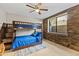 Bedroom with stacked stone accent wall, bunk beds, ceiling fan, and exterior view from window at 11773 E Desert Trail Rd, Scottsdale, AZ 85259