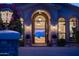 Elegant home entrance featuring a decorative iron gate, arched doorway, and manicured plants at 11773 E Desert Trail Rd, Scottsdale, AZ 85259