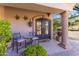 Home's front porch with stone accents, stylish chairs, and a custom front door at 11773 E Desert Trail Rd, Scottsdale, AZ 85259