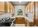 This laundry room features tan countertops, wooden cabinets, stainless steel washer and dryer, and a window at 11773 E Desert Trail Rd, Scottsdale, AZ 85259