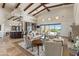 Bright living room features high ceilings, wooden beams, and a wet bar with access to outdoor patio with desert views at 11773 E Desert Trail Rd, Scottsdale, AZ 85259