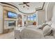 Cozy main bedroom features a fireplace, television, sitting area with mountain views and a luxurious king-sized bed at 11773 E Desert Trail Rd, Scottsdale, AZ 85259