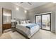 Bright main bedroom featuring a sliding glass door, gray walls, and neutral toned floors at 11773 E Desert Trail Rd, Scottsdale, AZ 85259