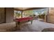 Outdoor entertainment area featuring a fireplace, dining table, and pool table at 11773 E Desert Trail Rd, Scottsdale, AZ 85259