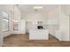 Well-appointed kitchen with white cabinetry, central island, wood floors, and modern appliances at 1447 E 12Th Pl, Casa Grande, AZ 85122