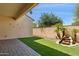 Covered patio with turf, stone, and water feature offer a private backyard space at 14844 W Pershing St, Surprise, AZ 85379