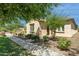 Inviting single-story home featuring lush green bushes and desert landscaping at 14844 W Pershing St, Surprise, AZ 85379