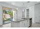 Bright kitchen island with granite countertop and stainless steel dishwasher, next to sliding glass doors to the patio at 14844 W Pershing St, Surprise, AZ 85379