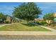 View of the neighborhood with landscaping, sidewalk, and a large shade tree at 14844 W Pershing St, Surprise, AZ 85379