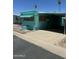 Turquoise mobile home featuring a covered carport and well-maintained gravel landscaping at 150 S Windsor Dr # 35, Mesa, AZ 85204