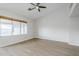 Bright bedroom featuring wood-look floors, a ceiling fan, and large windows at 1584 E Harrison E St, Chandler, AZ 85225
