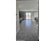 Spacious living area with tile flooring, sliding glass doors, and gray kitchen with an eat-in island in the background at 17423 W Country Club Ter, Surprise, AZ 85387