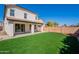 The backyard features a well-maintained lawn, a covered patio, and a block wall at 18123 W Lundberg St, Surprise, AZ 85388