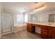 Spacious bathroom features dual vanity sinks, a soaking tub, glass shower, and window for natural light at 18123 W Lundberg St, Surprise, AZ 85388
