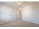 Carpeted bedroom featuring neutral walls, a ceiling fan, closet and doorway at 18123 W Lundberg St, Surprise, AZ 85388
