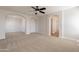 Primary bedroom with neutral carpet, recessed lighting, ceiling fan and arched doorways to other rooms at 18123 W Lundberg St, Surprise, AZ 85388
