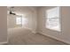Bedroom has neutral walls and carpet, a ceiling fan, and two windows to let the sunlight in at 18123 W Lundberg St, Surprise, AZ 85388