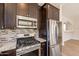Kitchen features granite countertops, stainless steel appliances, and stylish tile backsplash at 18123 W Lundberg St, Surprise, AZ 85388