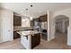 Modern kitchen with an island, stainless steel appliances, granite countertops, and dark wood cabinets at 18123 W Lundberg St, Surprise, AZ 85388