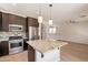 Bright kitchen features granite countertops, stainless steel appliances, and center island with pendant lighting at 18123 W Lundberg St, Surprise, AZ 85388