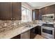 This stunning kitchen features granite counters, stainless appliances, and a gorgeous tile backsplash at 18123 W Lundberg St, Surprise, AZ 85388