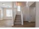 View of living room with staircase leading to the second floor, hardwood floors, neutral walls and bright natural lighting at 18123 W Lundberg St, Surprise, AZ 85388