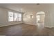 Open-concept living room with hardwood floors, lots of natural light, neutral walls and arched doorways for easy flow at 18123 W Lundberg St, Surprise, AZ 85388