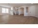 Spacious living room boasting hardwood floors, neutral paint, lots of windows, and open access to staircase and other rooms at 18123 W Lundberg St, Surprise, AZ 85388