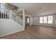 Bright and airy living room with hardwood floors, neutral paint, and an open staircase leading to the second floor at 18123 W Lundberg St, Surprise, AZ 85388