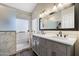 Modern main bathroom featuring double sinks, a shower, and marble-style tile at 19002 N 25Th Pl, Phoenix, AZ 85050