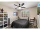 Cozy bedroom featuring a ceiling fan, window, and shelving filled with collectibles at 19002 N 25Th Pl, Phoenix, AZ 85050
