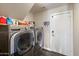 Well-equipped laundry room with a front-load washer and dryer set and ample shelving at 19002 N 25Th Pl, Phoenix, AZ 85050