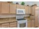 Eat-in kitchen with tile floors, tan cabinets, granite countertops, and stainless steel appliances at 19860 N 110Th Ln, Peoria, AZ 85373