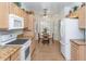 Eat-in kitchen with tile floors, tan cabinets, granite countertops, and stainless steel appliances at 19860 N 110Th Ln, Peoria, AZ 85373