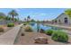 Scenic water view with lush landscaping, desert accents, and a walking path under a clear blue sky at 19860 N 110Th Ln, Peoria, AZ 85373